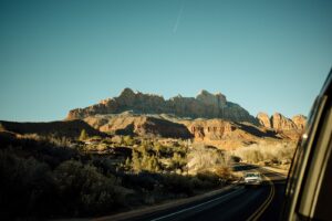 Driving towards rocky mountains under clear blue sky