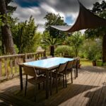 brown wooden table with chairs and umbrella