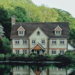 concrete house near a body of water and forest