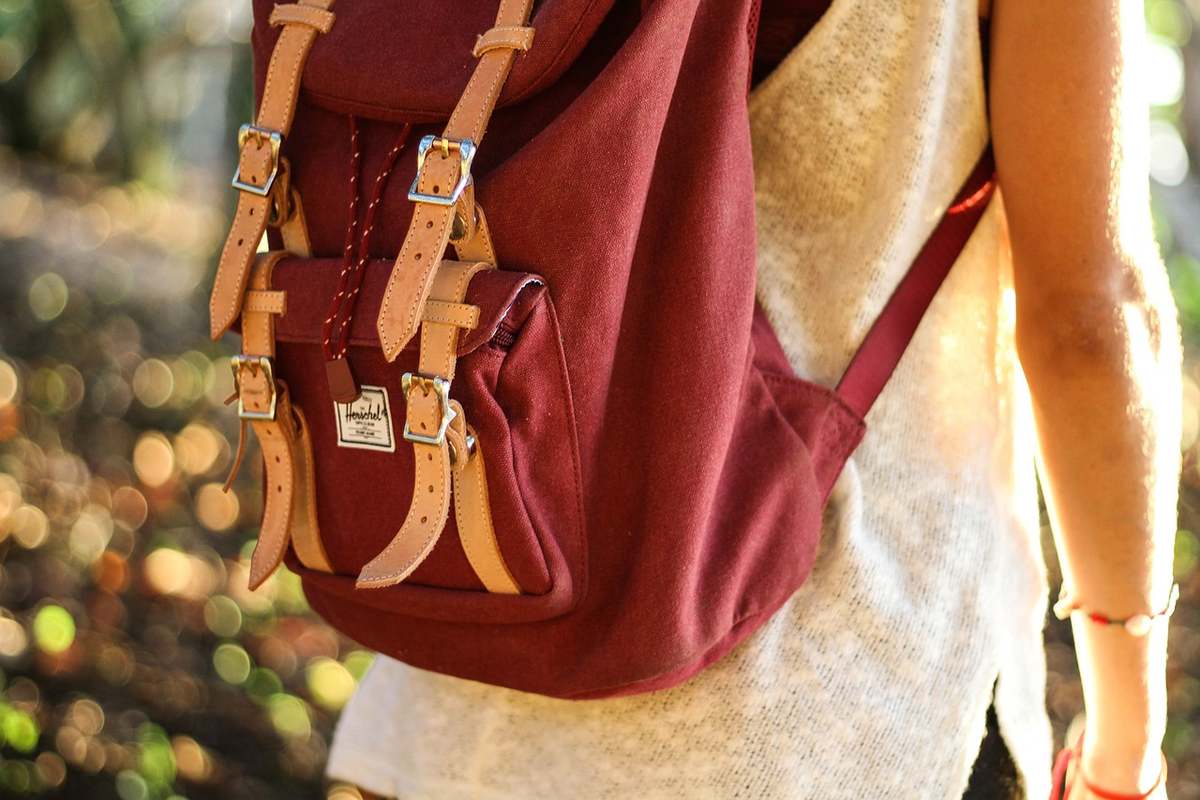 une personne en extérieur avec un sac à dos marron une personne en extérieur avec un sac à dos marron